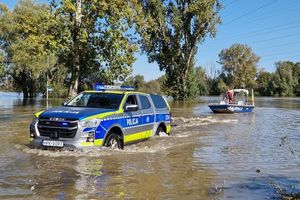 Radiowóz woduje wódkę na terenie zalanym.