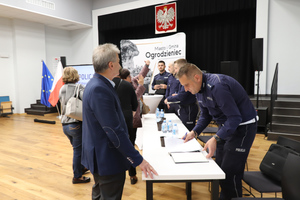 Na zdjęciu widoczni policjanci, którzy rozmawiają z uczestnikami debaty.