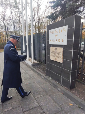 Na zdjęciu Komendant Powiatowy Policji w Zawierciu inspektor Jacek Kurdybelski niesie znicz pod pamiątkowe tablice.