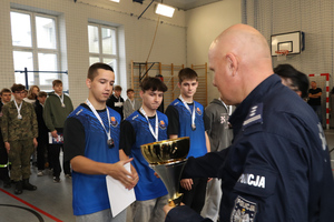 Na zdjęciu widoczny Komendant Powiatowy Policji w Zawierciu inspektor Jacek Kurdybelski, który wręcza puchar i składa gratulacje drużynie.