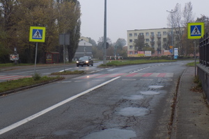 Na zdjęciu widoczne przejście dla pieszych i jadący samochód.