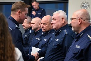 Na zdjęciu widoczny Pierwszy Zastępca Komendanta Wojewódzkiego Policji w Katowicach inspektor Radosław Kacprzak, który gratuluje aspirantowi sztabowemu Mirosławowi Marczykowi.