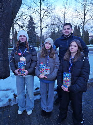 Na zdjęciu widoczny policjant oraz trzy wolontariuszki z puszkami.