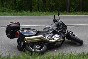 Na zdjęciu widoczny motocykl, który leży na jezdni.