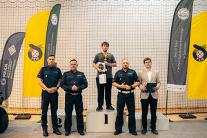 Na zdjęciu widoczni policjanci oraz zawodnik na podium.