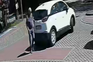 Na zdjęciu widoczny biały samochód osobowy oraz mężczyzna, który nim kierował.