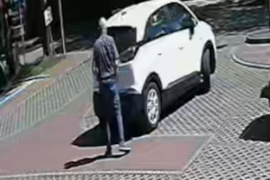Na zdjęciu widoczny biały samochód osobowy oraz mężczyzna, który nim kierował.