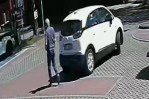 Na zdjęciu widoczny biały samochód osobowy oraz mężczyzna, który nim kierował.
