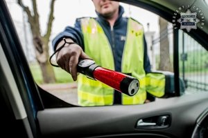 Na zdjęciu policjant z alkosensorem.
