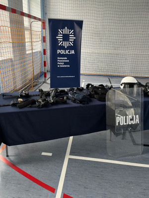 Na zdjęciu widoczne ustawione na sali gimnastycznej stoisko z policyjnym sprzętem.