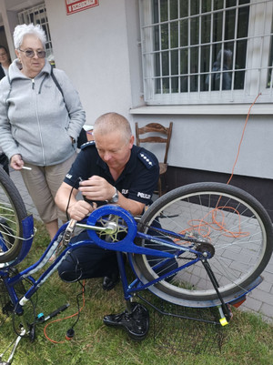 Na zdjęciu widoczny dzielnicowy, który znakuje rower.