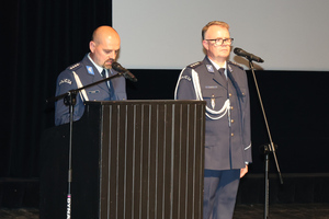 Na zdjęciu widoczny aspirant Marcin Stanek, który przemawia z mównicy.