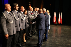 Na zdjęciu widoczni policjanci, którzy otrzymują akty mianowania i gratulacje od Zastępcy Komendanta Wojewódzkiego Policji w Katowicach podinspektora Marka Gadzińskiego oraz Komendanta Powiatowego Policji w Zawierciu inspektora Artura Klimka.