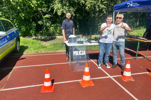 Na zdjęciu widoczny policjant oraz starszy mężczyzna i chłopiec.