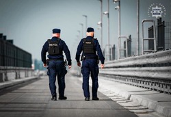 Na zdjęciu widoczni dwaj idący policjanci.