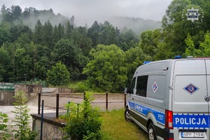 Na zdjęciu widoczny radiowóz stojący w pobliżu rzeki.