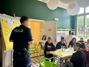 Na zdjęciu widoczny policjant prowadzący warsztaty, a także widoczni uczestnicy warsztatów.