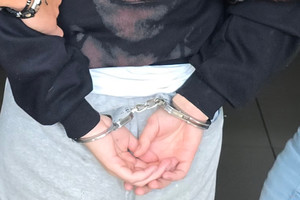 Na zdjęciu widoczne ręce trzymane z tyłu, na które założone są kajdanki.