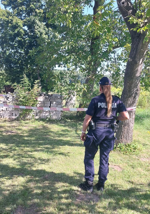 Na zdjęciu widoczna policjantka, która pilnuje miejsca ujawnienia niewybuchu.