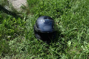Na zdjęciu widoczny kask ochronny leżący na trawie.