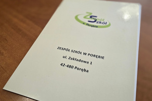 Na zdjęciu widoczna teczka z napisem Zespół Szkół w Porębie oraz danymi adresowymi placówki.