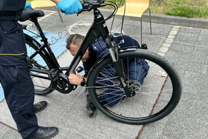 Na zdjęciu widoczny policjant, który znakuje rower.