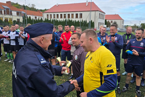Na zdjęciu widoczny Pierwszy Zastępca Komendanta Powiatowego Policji w Zawierciu podinspektor Paweł Sobota, który wręcza puchary sędziom turnieju.