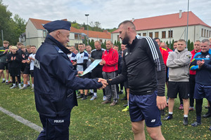 Na zdjęciu widoczny Pierwszy Zastępca Komendanta Powiatowego Policji w Zawierciu podinspektor Paweł Sobota, który wręcza dyplom kapitanowi drużyny.