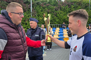 Na zdjęciu widoczny przedstawiciel zawierciańskiego Zarządu Terenowego NSZZ Policjantów aspirant sztabowy Dawid Cacoń, który wręcza puchar zawodnikowi.