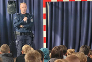Na zdjęciu widoczny policjant podczas prelekcji dla uczniów.