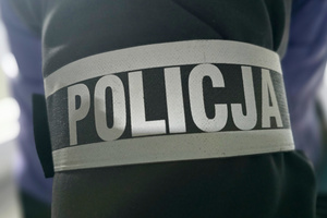 Na zdjęciu widoczna opaska z napisem POLICJA.