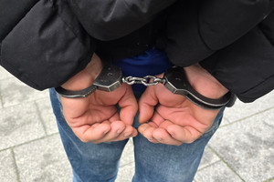 Na zdjęciu widoczne ręce zatrzymanego mężczyzny, na które ma założone kajdanki.