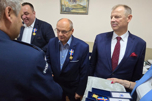 Na zdjęciu widoczny moment wręczania odznaczeń przez policjanta.