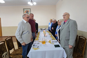 Na zdjęciu widoczni stojący przy stole uczestnicy uroczystości.