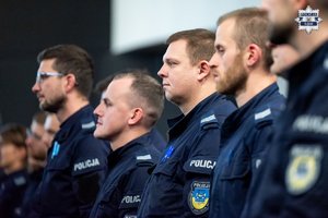 Na zdjęciu widoczni stojący w szeregu policjanci.