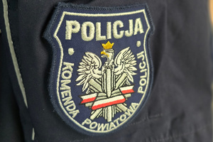 Na zdjęciu widoczna naszywka z białym orłem w koronie, a także z biało-czerwoną wstęgą oraz napisem: Policja. Komenda Powiatowa Policji.