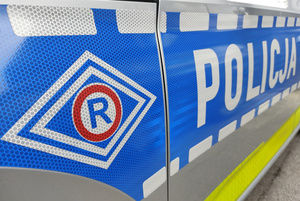 Na zdjęciu częściowo widoczny radiowóz ruchu drogowego.