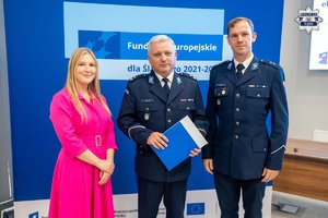 Na zdjęciu widoczny Zastępca Komendanta Wojewódzkiego Policji w Katowicach podinspektor Marek Gadziński, a obok niego stoi kobieta i inny policjant.