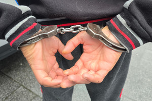 Na zdjęciu widoczne ręce zatrzymanego mężczyzny, które trzyma z tyłu i ma na nich założone kajdanki.