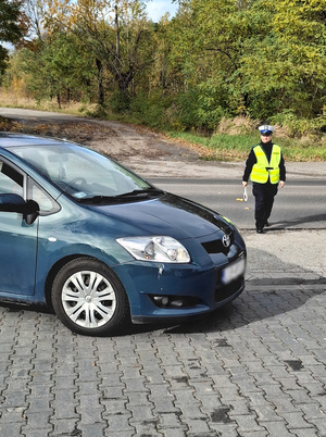 Na zdjęciu widoczna policjantka, podchodząca do samochodu.
