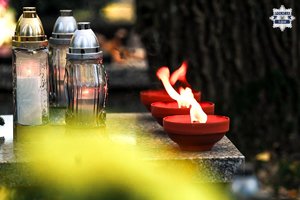 Na zdjęciu widoczne palące się na grobie znicze.