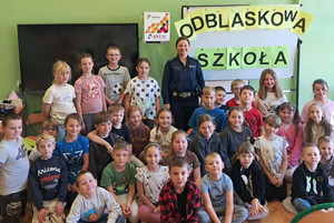 Zdjęcie grupowe, na którym widoczna jest policjantka oraz dzieci.
