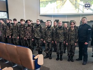 Na zdjęciu widoczny policjant oraz uczniowie w mundurach.