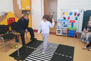 Na zdjęciu widoczny policjant oraz przedszkolaki podczas spotkania.