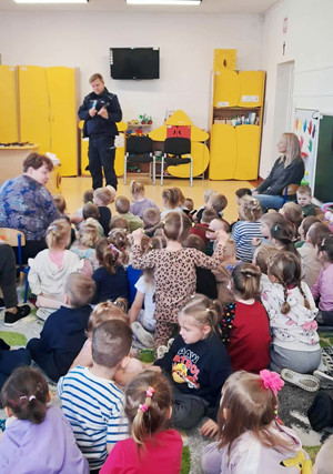 Na zdjęciu widoczny policjant oraz przedszkolaki podczas spotkania.