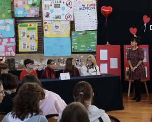 Na zdjęciu widoczni uczniowie siedzący przy stoliku z ekspertem.