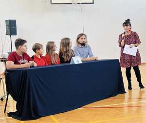 Na zdjęciu widoczni uczniowie siedzący przy stoliku z ekspertem.