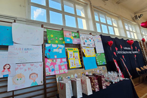 Na zdjęciu widoczne prezentowane prace plastyczne oraz napis na kotarze: Dzieciństwo bez Przemocy.