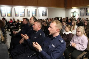 Na zdjęciu widoczni goście siedzący na sali, w tym policjanci i dzieci.
