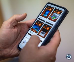 Na zdjęciu widoczny smartfon trzymany w dłoniach, na którym wyświetlone są oferty sprzedażowe.